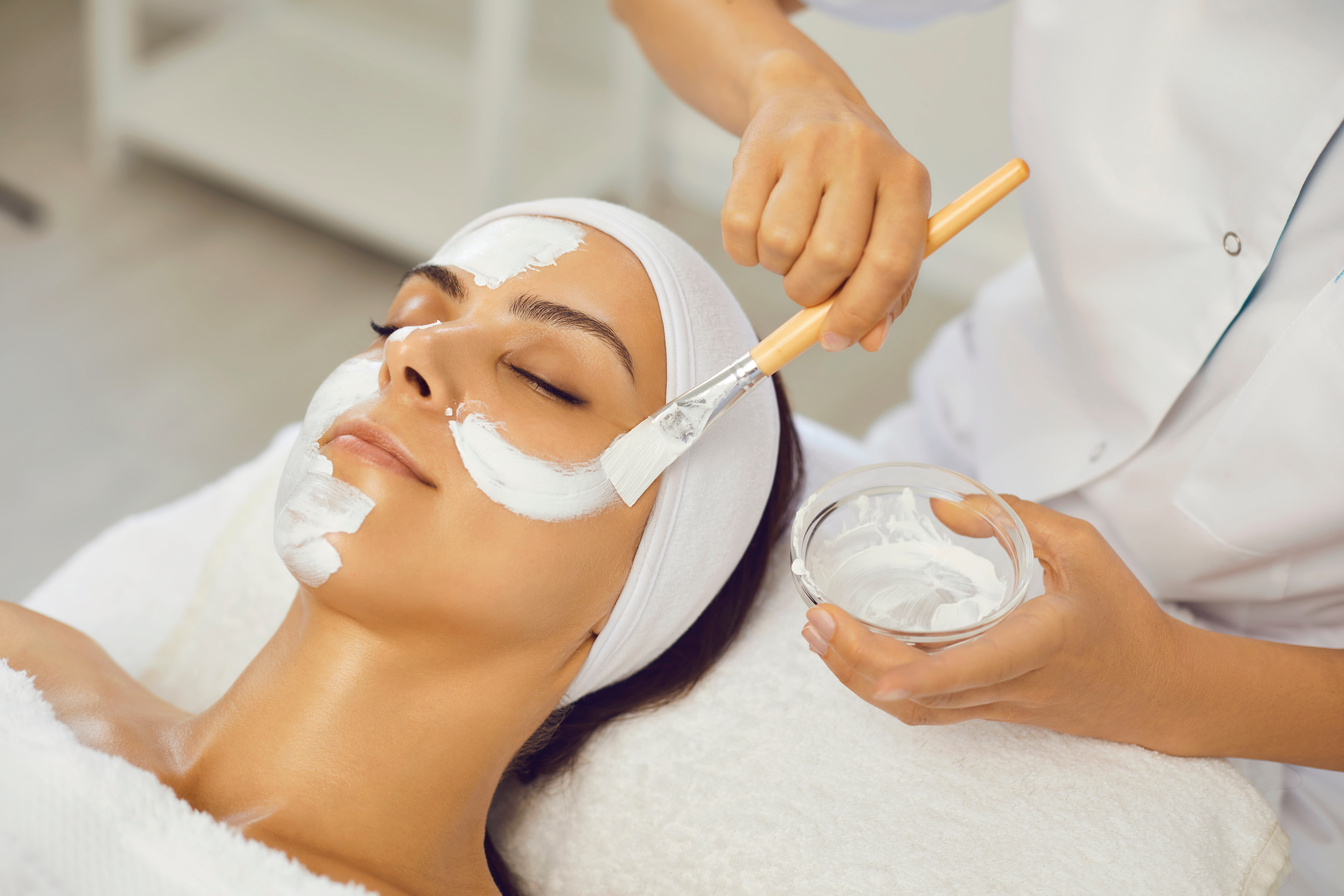 Cosmetologist Smearing Mask for Serene Woman in Beauty Spa Salon